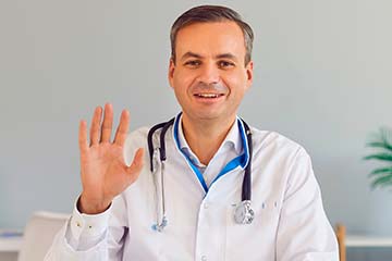 мужчина врач приветствует жестом руки
